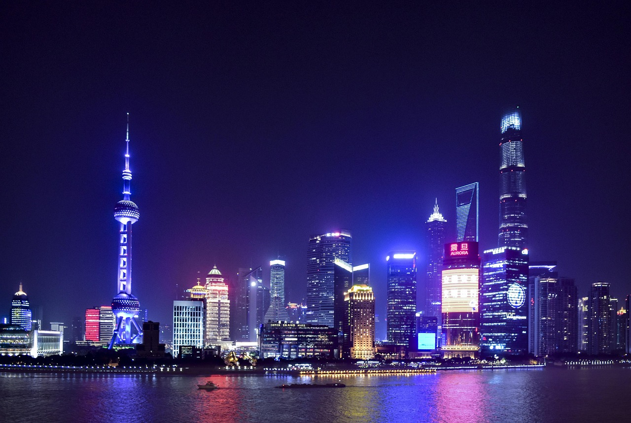 Shanghai skyline at night with glowing skyscrapers Night view of Shanghai skyline with illuminated skyscrapers and reflections on the Huangpu River