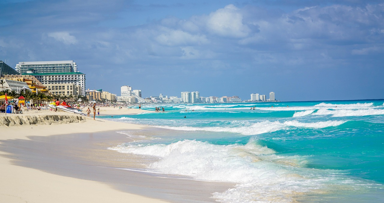 Sunny beach with waves and hotels Sunny beach with turquoise waves, white sand, and beachfront hotels under a partly cloudy sky