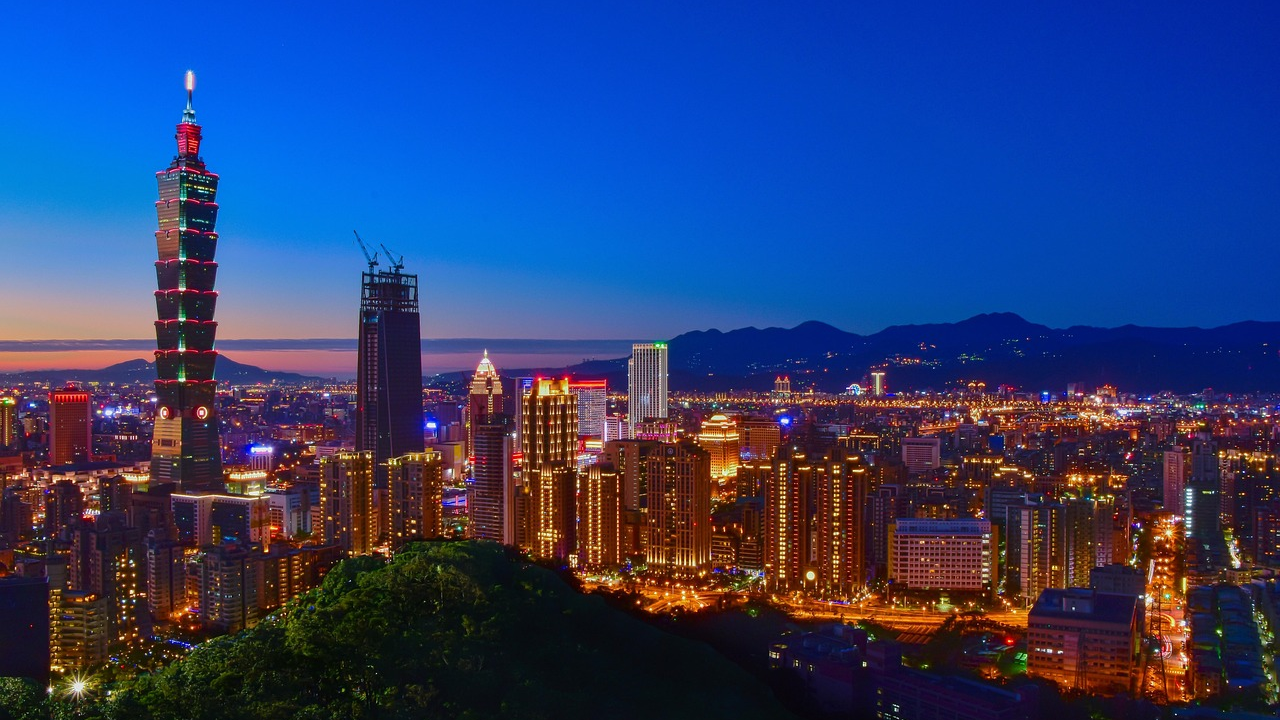 Taipei city skyline with Taipei 101 at night Night skyline of Taipei city with illuminated Taipei 101 tower and surrounding buildings under clear blue sky