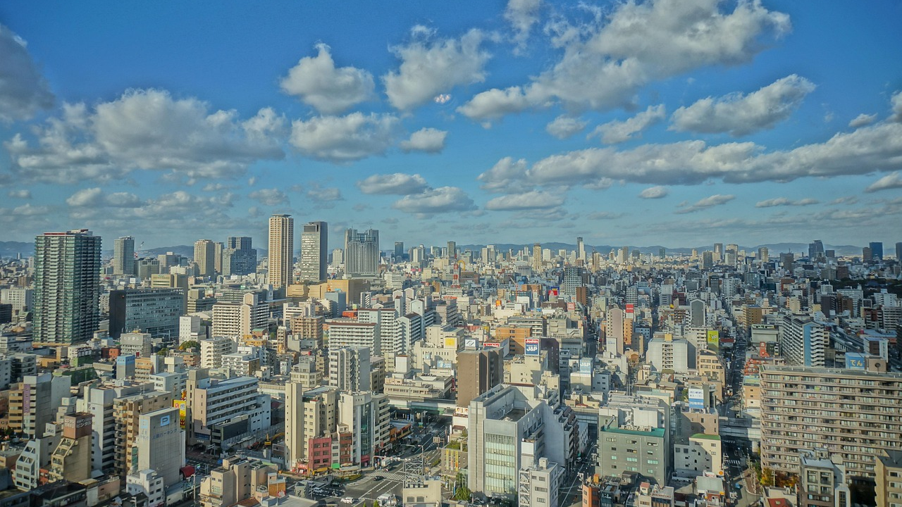 Urban cityscape with high-rise buildings and blue sky Panoramic view of a dense urban cityscape with high-rise buildings under a blue sky with scattered clouds