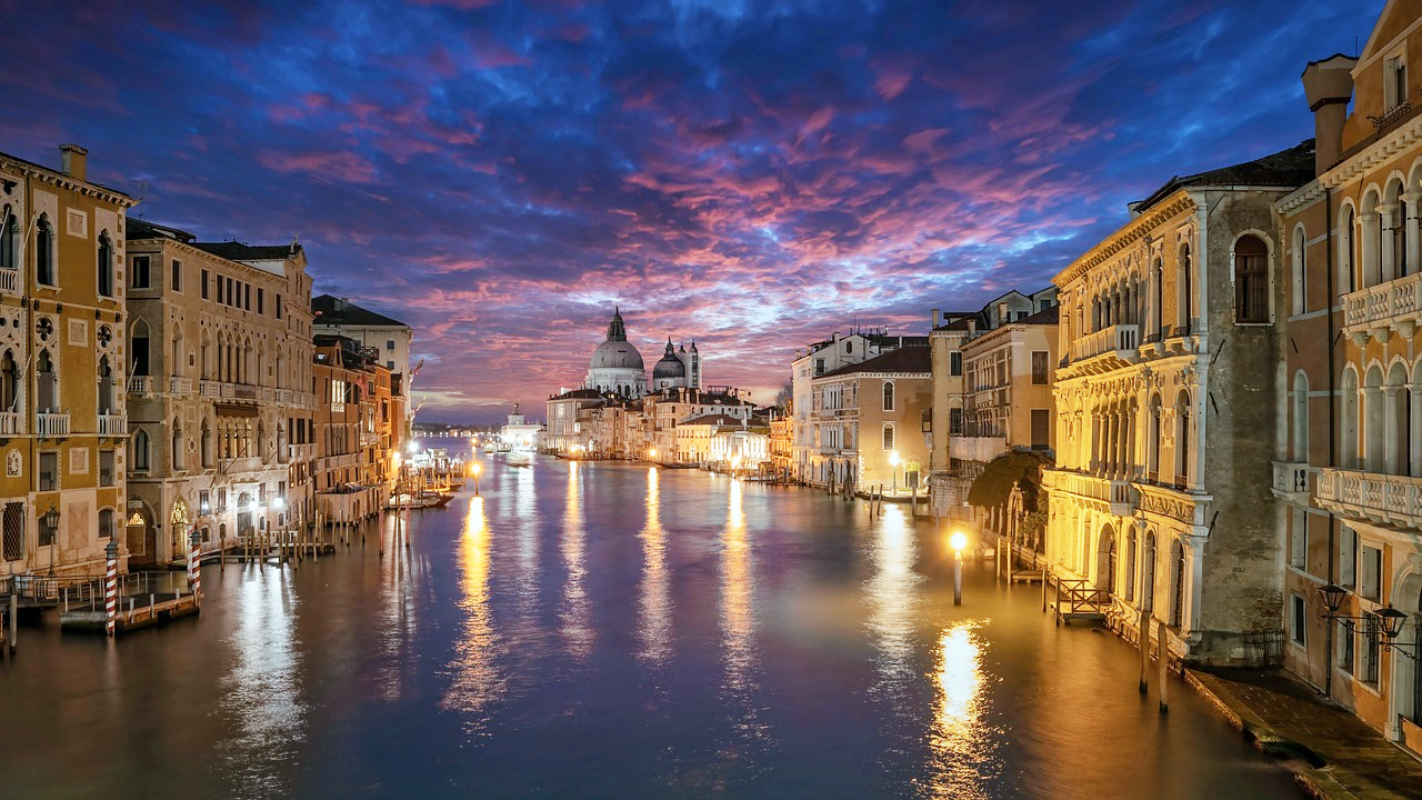 Venice canal sunset with historic buildings Venice canal at sunset with historic buildings and vibrant sky reflecting on water, iconic Italian cityscape