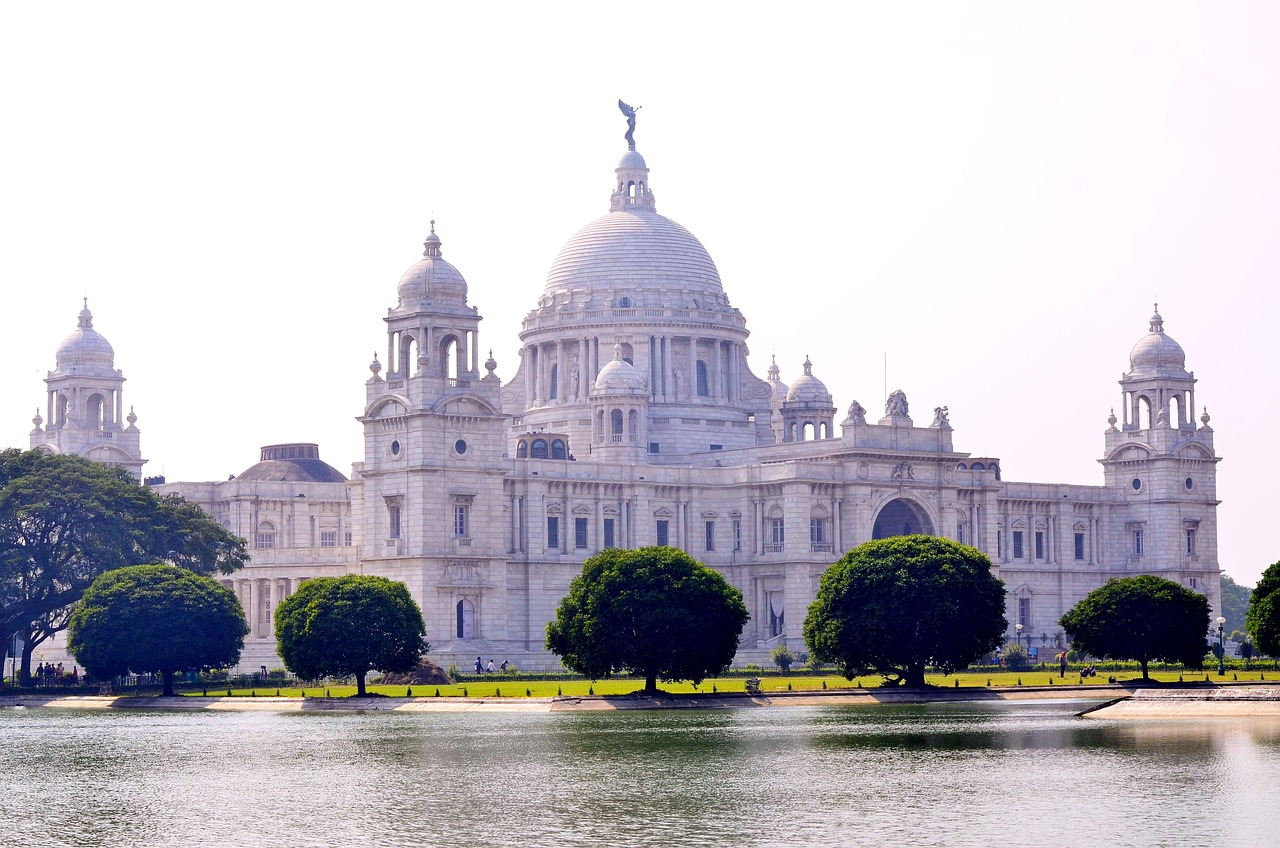 Victoria Memorial Kolkata white marble monument Victoria Memorial Kolkata majestic white marble building with domes and statues near water body and green trees