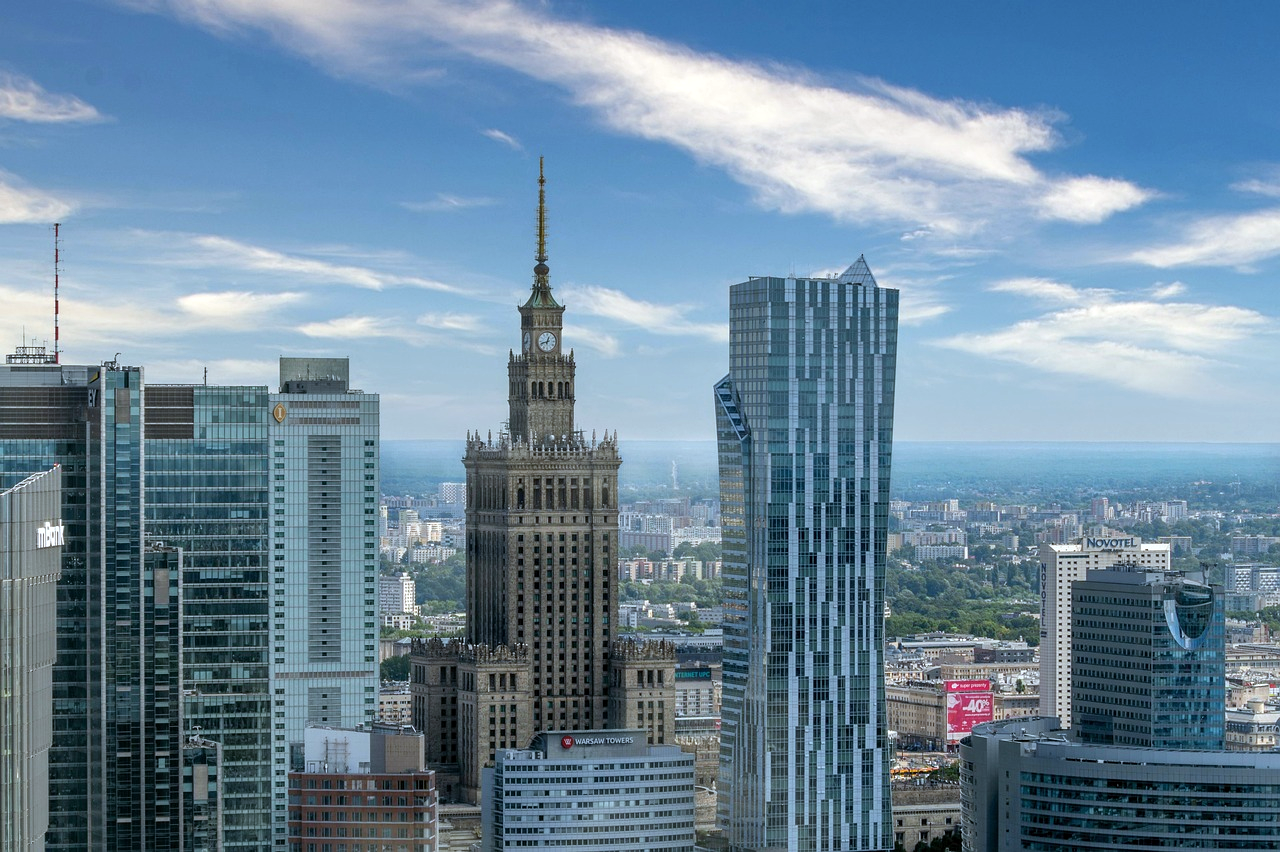 Warsaw skyline with Palace of Culture and Science Skyline of Warsaw featuring modern skyscrapers and the historic Palace of Culture and Science under a blue sky