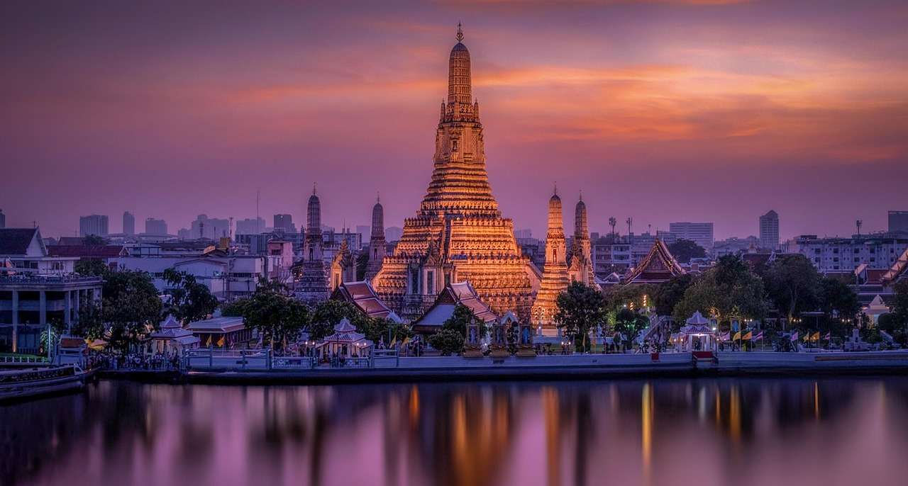 Wat Arun temple sunset reflection Bangkok Wat Arun temple at sunset with vibrant purple and orange sky reflecting on the river in Bangkok, Thailand