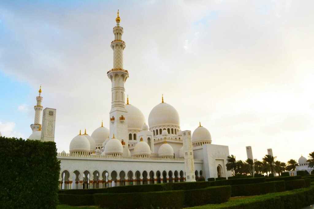 Stunning view of the Sheikh Zayed Grand Mosque in Abu Dhabi at daybreak — the white marble Islamic architecture with its 82 domes catching the early morning light