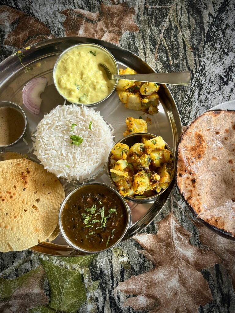 Authentic Indian thali featuring rice, curries, flatbread, and papad — classic Mughlai-influenced North Indian dining