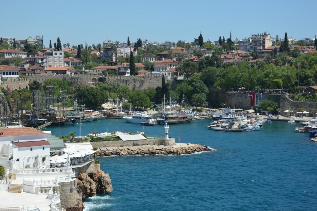 Beautiful view of Antalya's historic Roman harbour with boats and the vibrant Kaleiçi old town backdrop