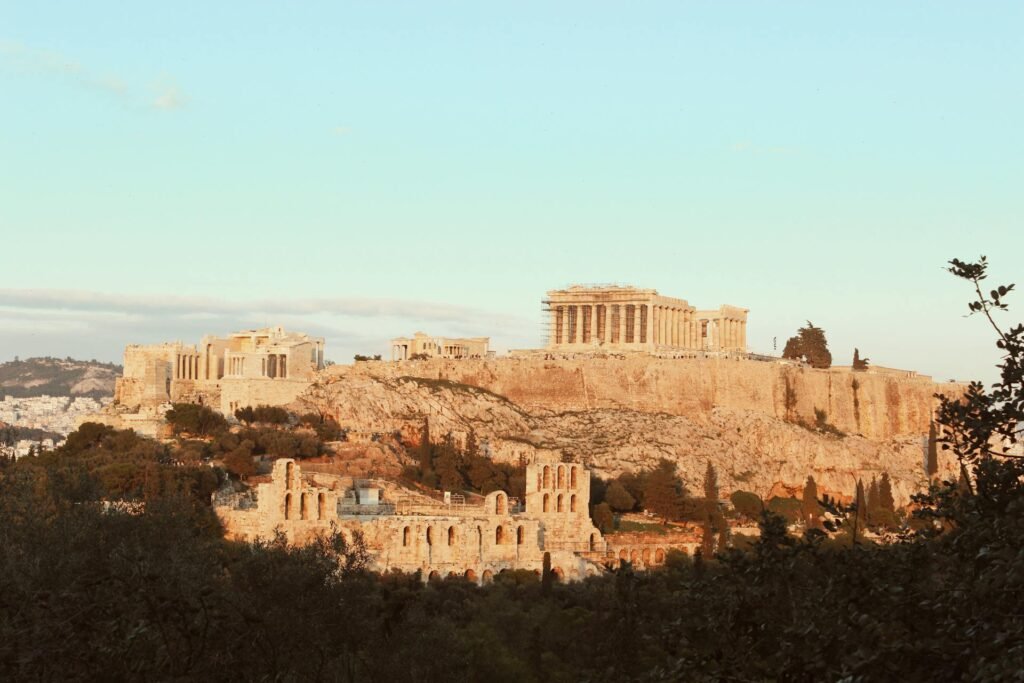 The iconic Acropolis of Athens — a UNESCO World Heritage Site — bathed in warm sunset light, with the 5th-century BCE Parthenon standing as the most photographed archaeological monument in the world