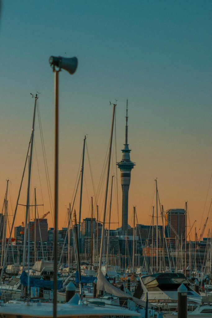 Beautiful sunset view of Auckland's marina with sailboats moored in the Viaduct Harbour and the Sky Tower in the background — the City of Sails earning its name through the world's highest per-capita boat ownership