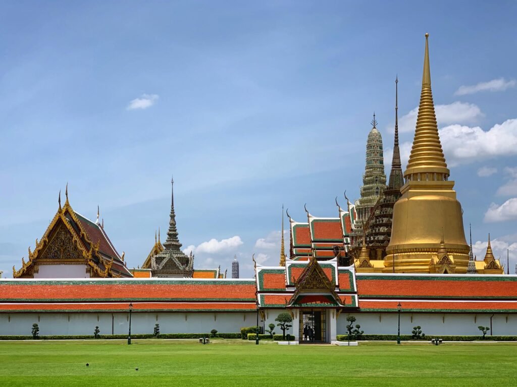 The Grand Palace in Bangkok with its golden chedis and traditional Thai architecture under clear sky