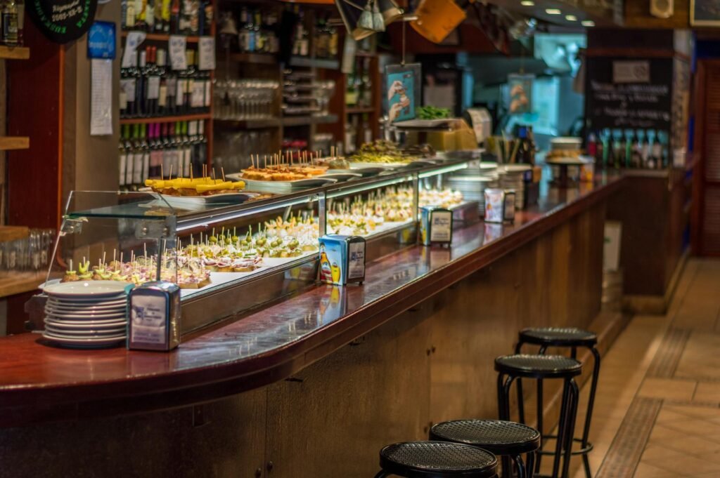 A vibrant pincho display at a Barcelona tapas bar counter showing Catalan culinary tradition