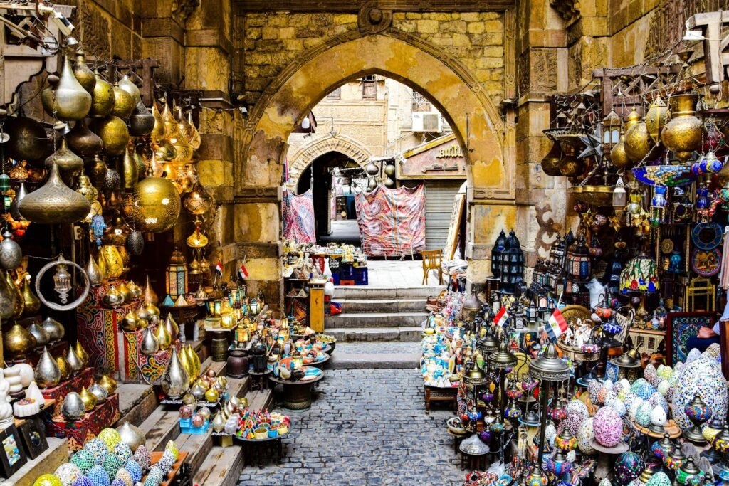 A narrow alley in the Khan el-Khalili bazaar in Islamic Cairo, lined with hanging brass lanterns and traditional craft stalls