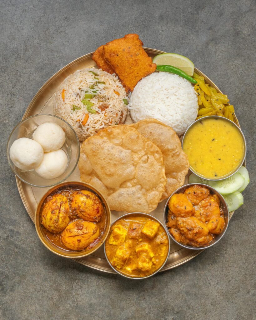 Traditional South Indian thali featuring rice, sambar, rasam, multiple curries, and condiments served on a brass plate