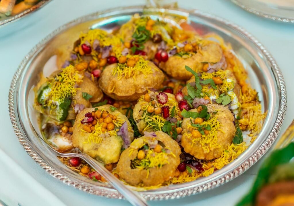 Plate of crunchy pani puri (gol gappa) topped with colorful garnishes, classic Delhi street food