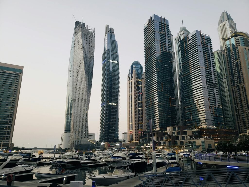 Dubai Marina at dusk with luxury yachts in the harbor and skyscrapers towering around the artificial inlet