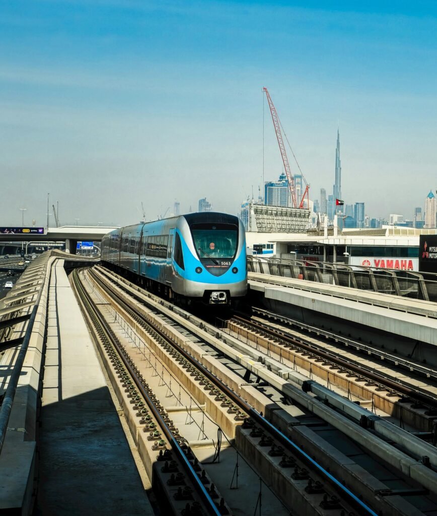 A driverless Dubai Metro train on elevated tracks with the Burj Khalifa visible in the skyline