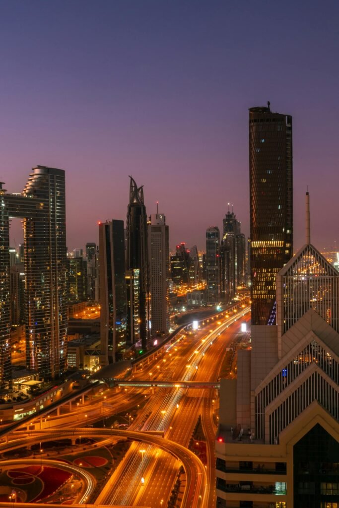 Dubai's modern skyline at twilight with illuminated roads and skyscrapers, capturing the city's economic scale