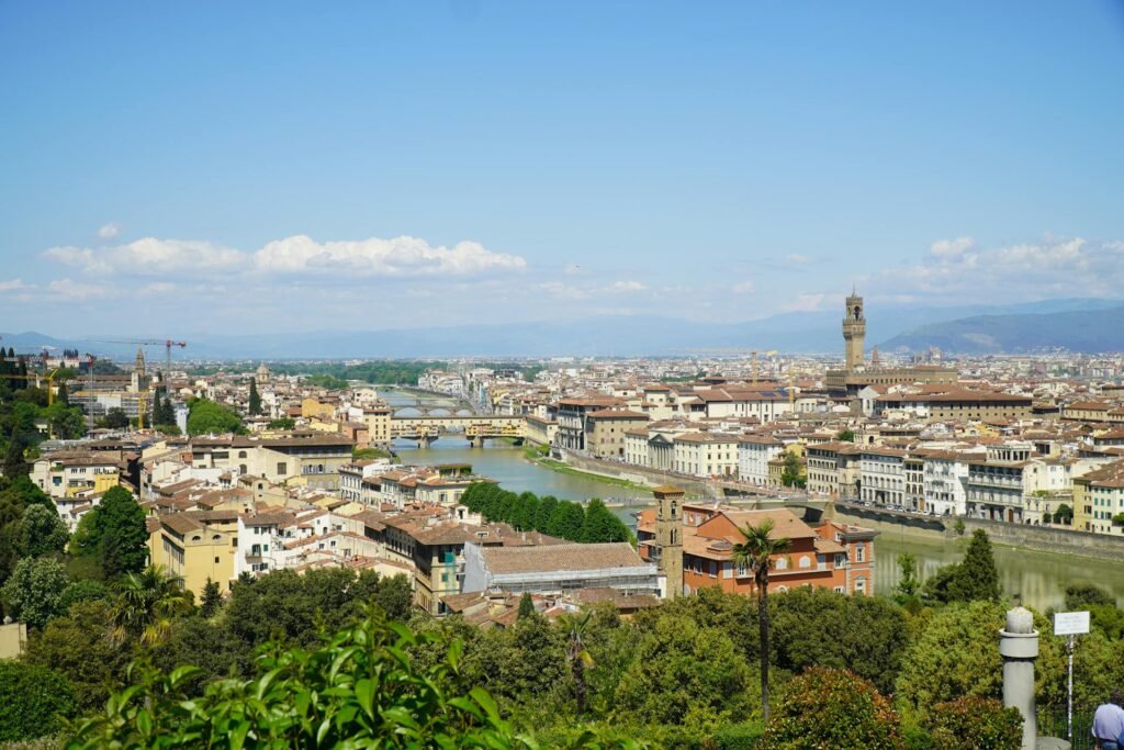 Breathtaking aerial view of Florence showcasing the iconic Renaissance architecture, the Arno River winding through the historic center, and the surrounding Tuscan hills