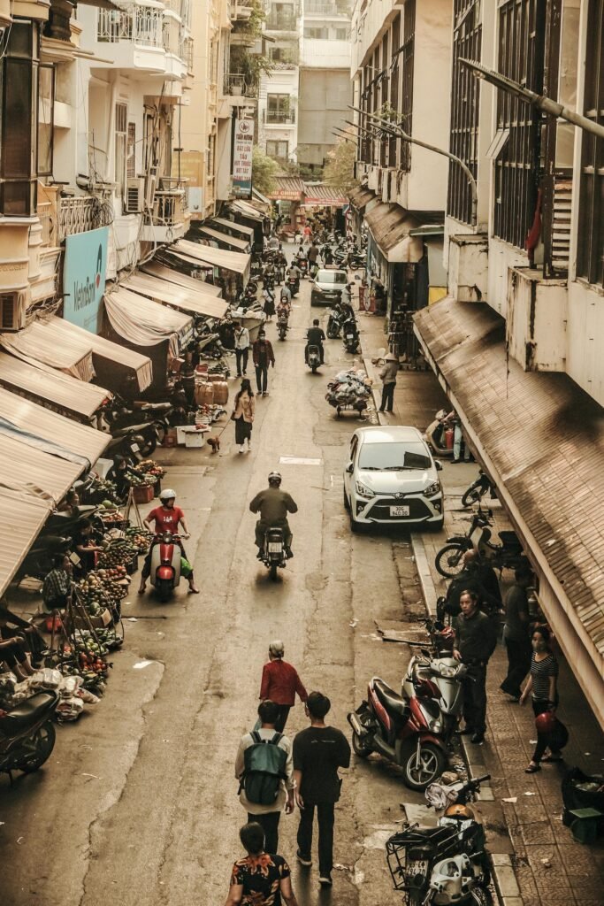 Vibrant scene of Hanoi's market street showcasing daily life and urban activity — vendors, baskets, and the city's culinary culture in motion