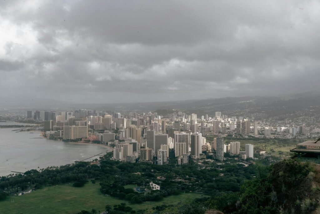 Panoramic view of Honolulu from Diamond Head — the iconic Hawaiian capital stretched along the south shore of Oʻahu with Waikiki Beach, the high-rise downtown, and the Koʻolau Range in the background