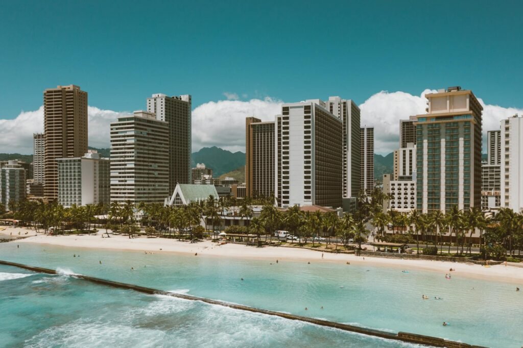 Waikiki Beach high-rise buildings backing the turquoise waters of the Pacific Ocean — the world-famous Honolulu resort strip that defines most international visitors' experience of Hawaiʻi
