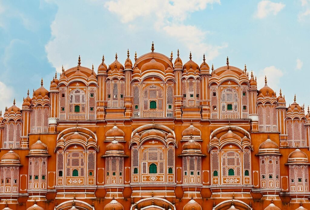 Iconic five-story facade of Hawa Mahal in Jaipur showcasing intricate Rajput architecture under a clear sky