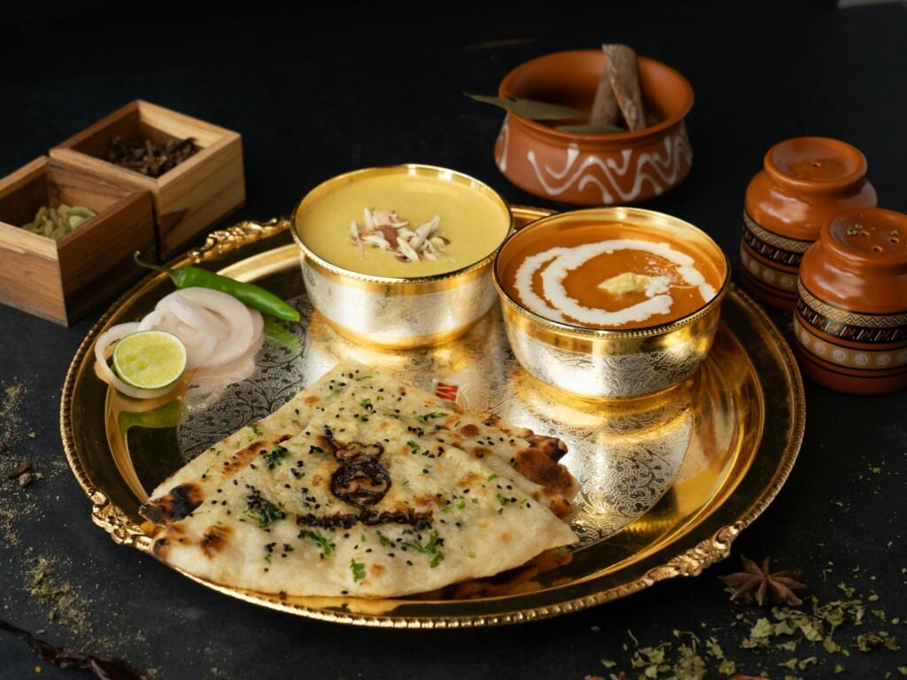 Delectable Indian thali featuring dal, butter chicken, and naan on a golden platter — classic Rajasthani dining