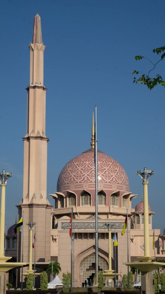 Beautiful Malaysian mosque with iconic pink dome and minaret against a clear blue sky — representing the Sultan Abu Bakar Mosque legacy in Johor Bahru