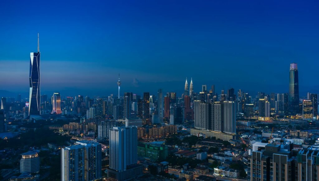 The Kuala Lumpur skyline at dusk featuring the city's iconic landmarks glowing in the evening light