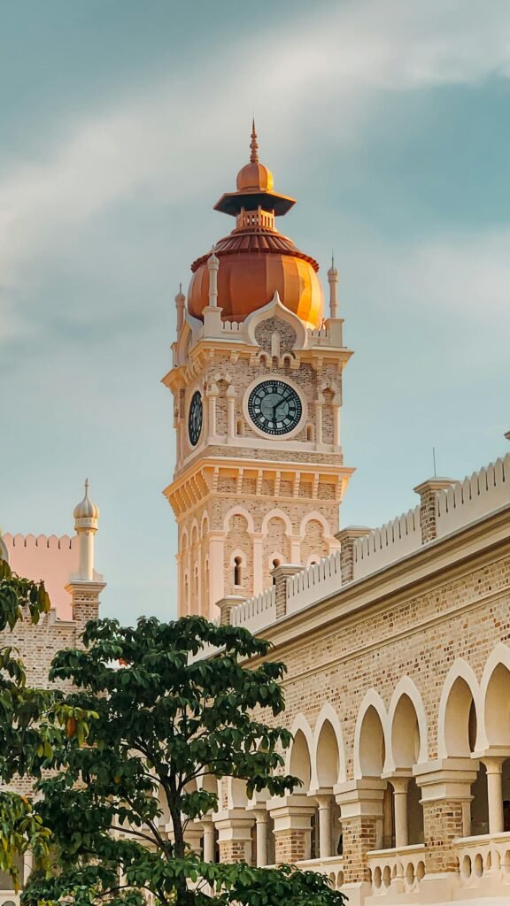 The Moorish copper-domed clock tower of the Sultan Abdul Samad Building at sunset in Kuala Lumpur, Malaysia