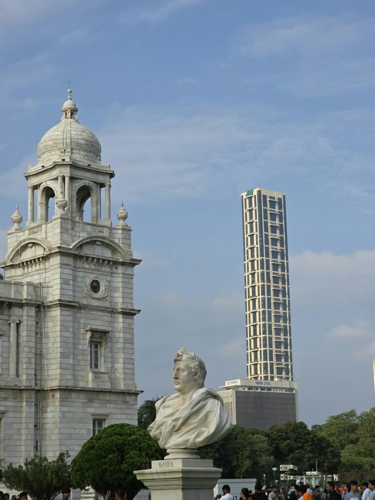 Victoria Memorial in Kolkata with the contemporary skyline backdrop — the 1906–1921 Indo-Saracenic white marble palace built to commemorate Queen Victoria, the architectural symbol of British India's former capital