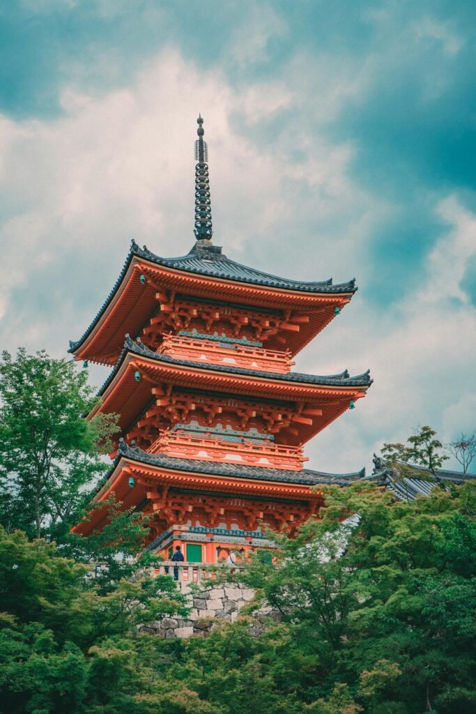 Kiyomizu-dera temple in Kyoto with the iconic pagoda and surrounding greenery — the 8th-century Buddhist temple perched on the eastern Higashiyama hillside with its famous 13-meter wooden veranda extending out from the cliff