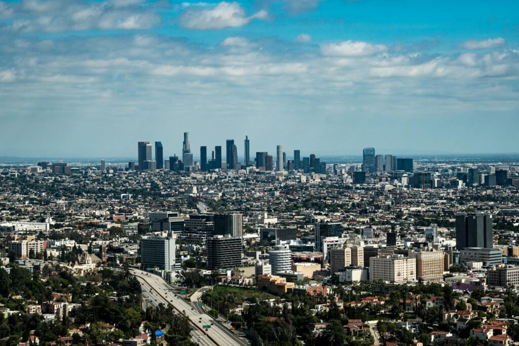 Aerial view of downtown Los Angeles high-rise skyline beneath bright blue skies