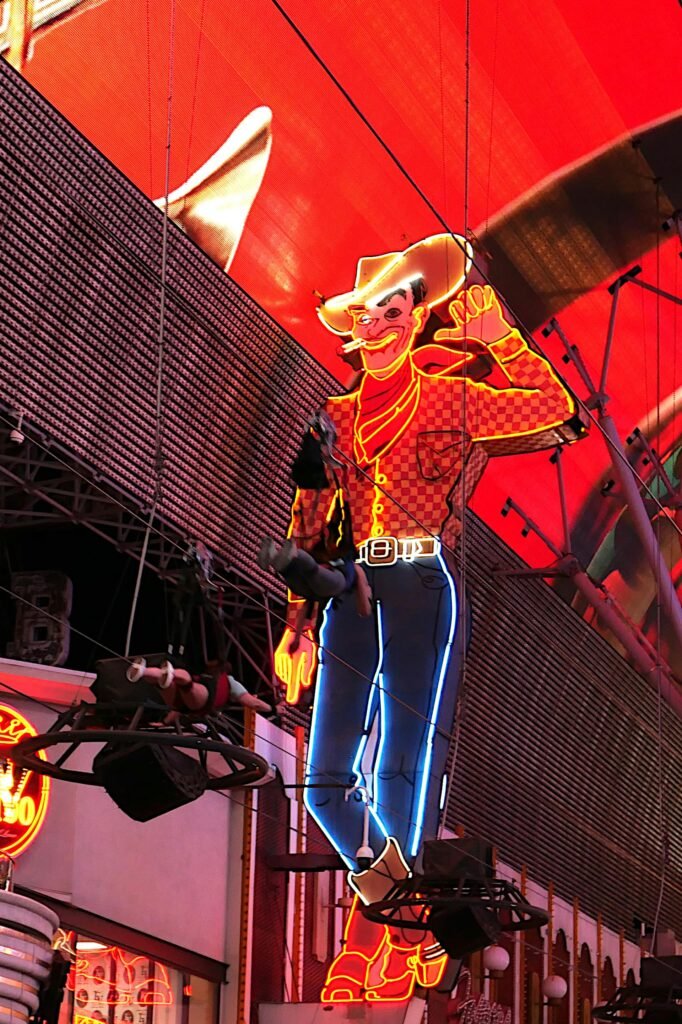 Iconic neon cowboy sign glowing brightly at the Fremont Street Experience in downtown Las Vegas