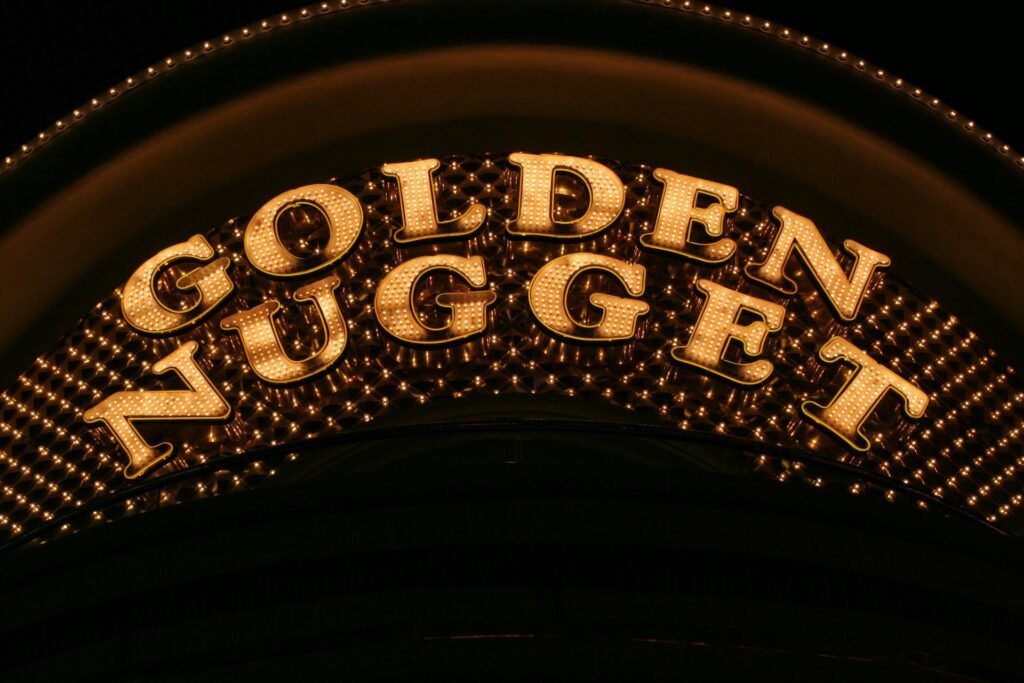 Illuminated Golden Nugget casino sign glowing brilliantly against the night sky in downtown Las Vegas
