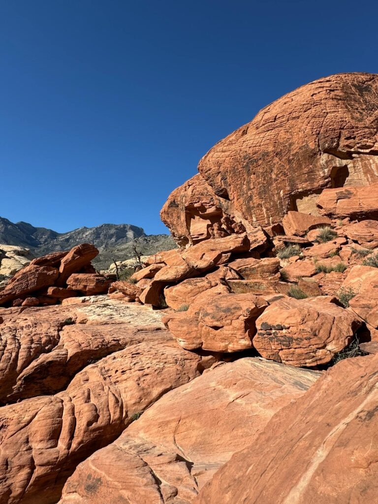 Majestic Red Rock Canyon landscape in Nevada with vibrant sandstone formations beneath clear blue skies, just 15 minutes from Las Vegas