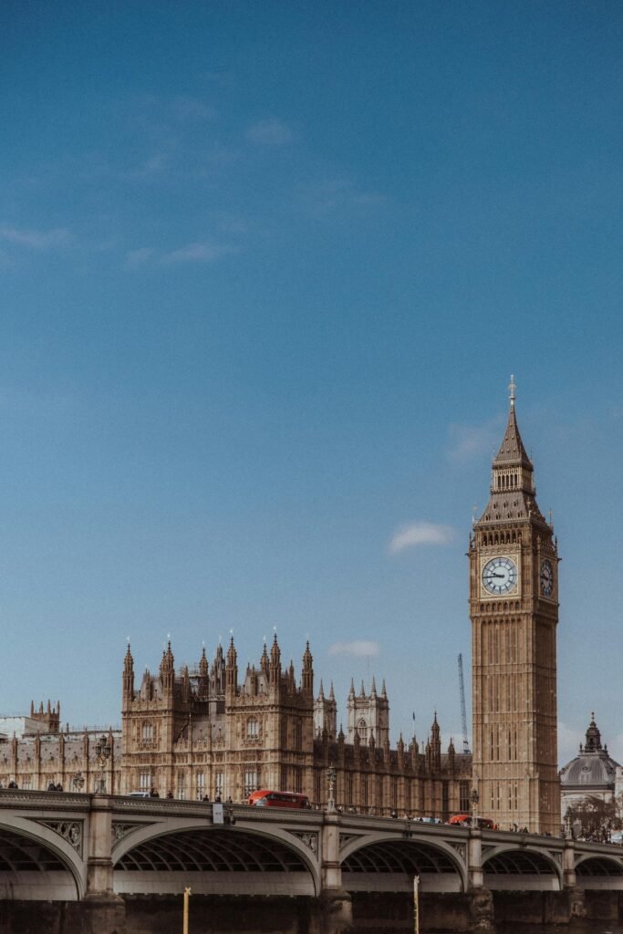 Iconic view of Big Ben clock tower and Westminster Bridge over the Thames in London under a blue sky