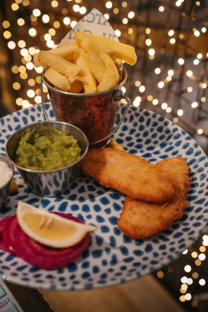 Traditional British fish and chips platter with mushy peas — classic London pub fare