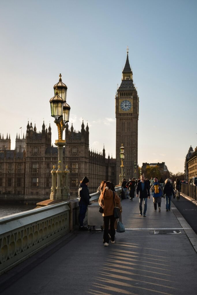 People walking on Westminster Bridge with Big Ben and Houses of Parliament — daily London life