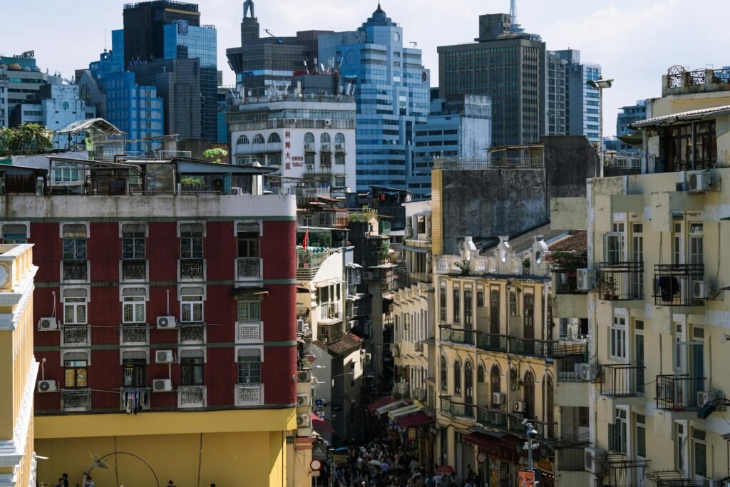 A street in Macau showing the contrast between historic Portuguese-era architecture and modern skyscrapers in the background