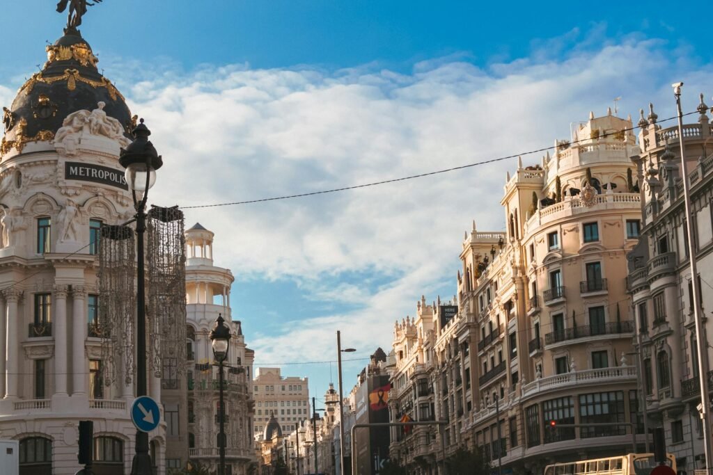 The iconic Metropolis Building on the corner of Gran Vía and Calle de Alcalá in central Madrid — the 1911 Beaux-Arts building topped by the winged Victory statue, one of Spain's most photographed urban landmarks