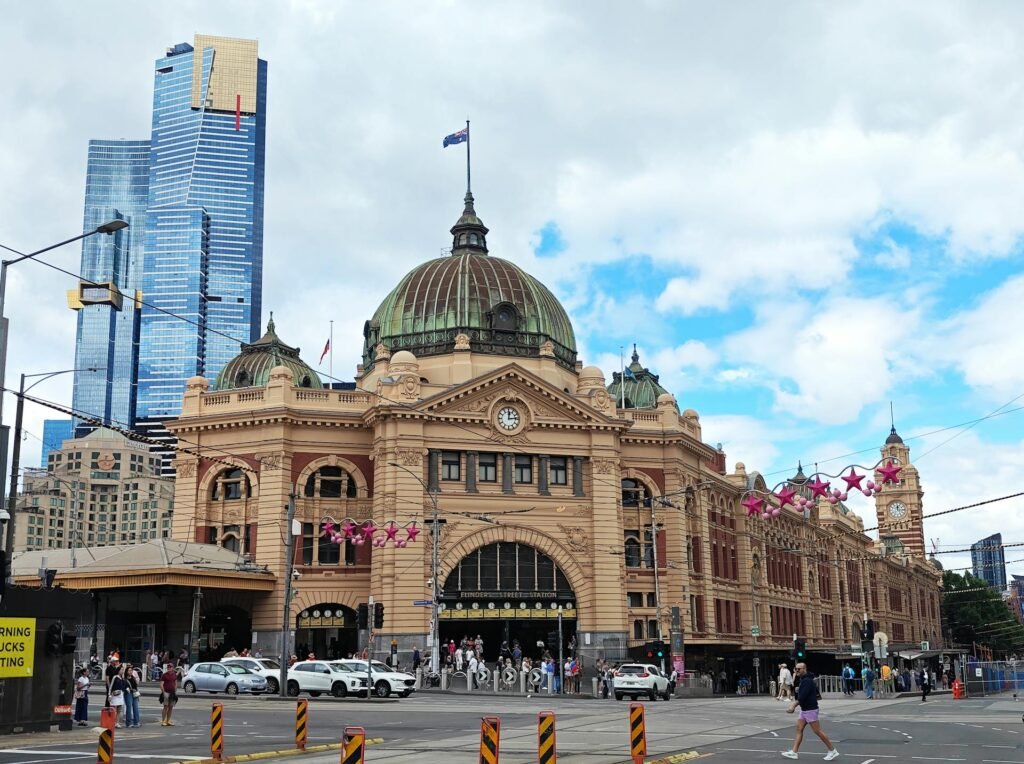The iconic Flinders Street Station in Melbourne — the 1909 clock-tower riverside terminus that anchors the city's Victorian-era architectural heritage and remains the primary suburban rail hub of the Hoddle Grid CBD