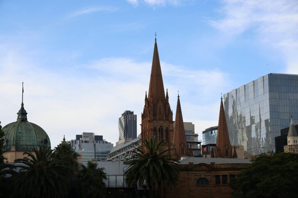 St Paul's Cathedral against the Melbourne skyline — the 1891 Gothic Revival Anglican cathedral that anchors Federation Square and the central CBD, the symbolic heart of historic Melbourne