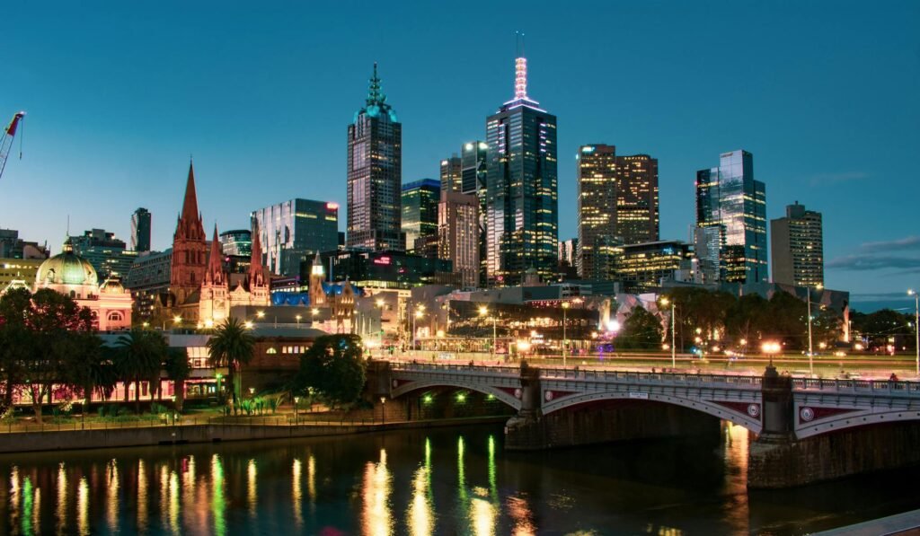 The Melbourne city skyline with the Yarra River and bridge reflecting at dusk — the iconic urban riverfront where Federation Square, Southbank, and the historic CBD converge