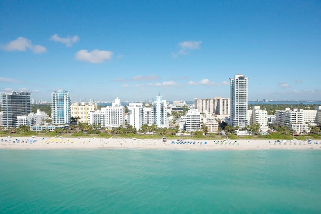 Stunning aerial view of Miami Beach skyline and pristine coastline under clear blue sky