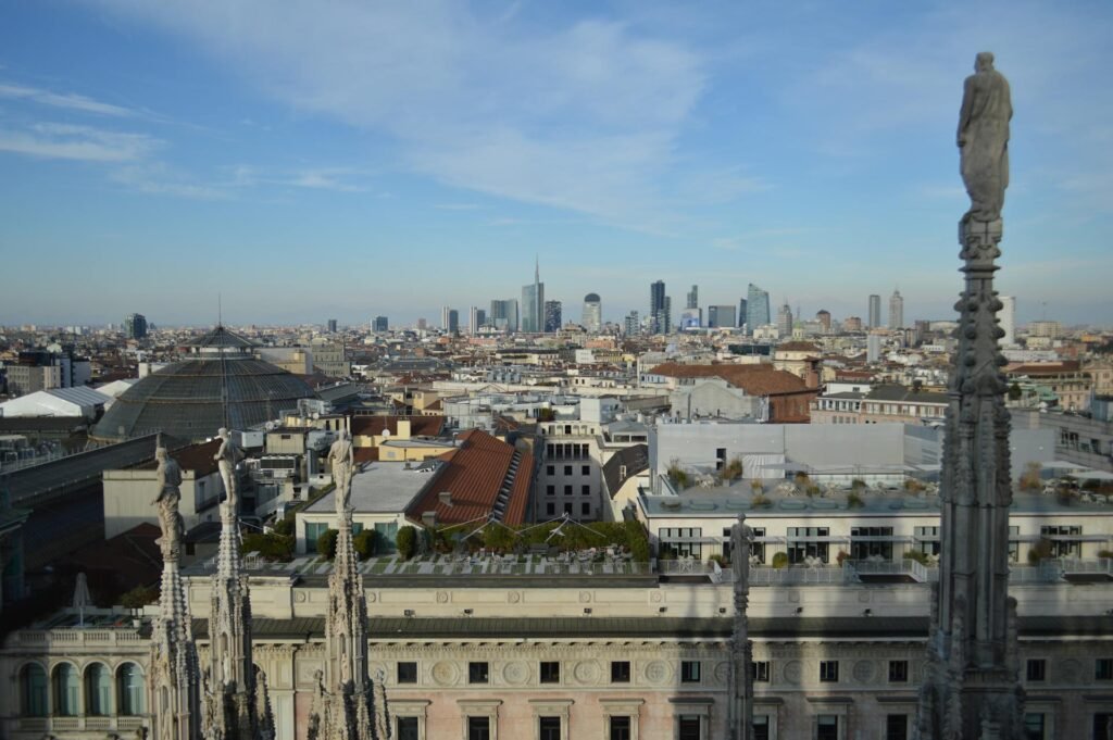 Panoramic aerial view of Milan cityscape from atop the Duomo, showing the historic city skyline