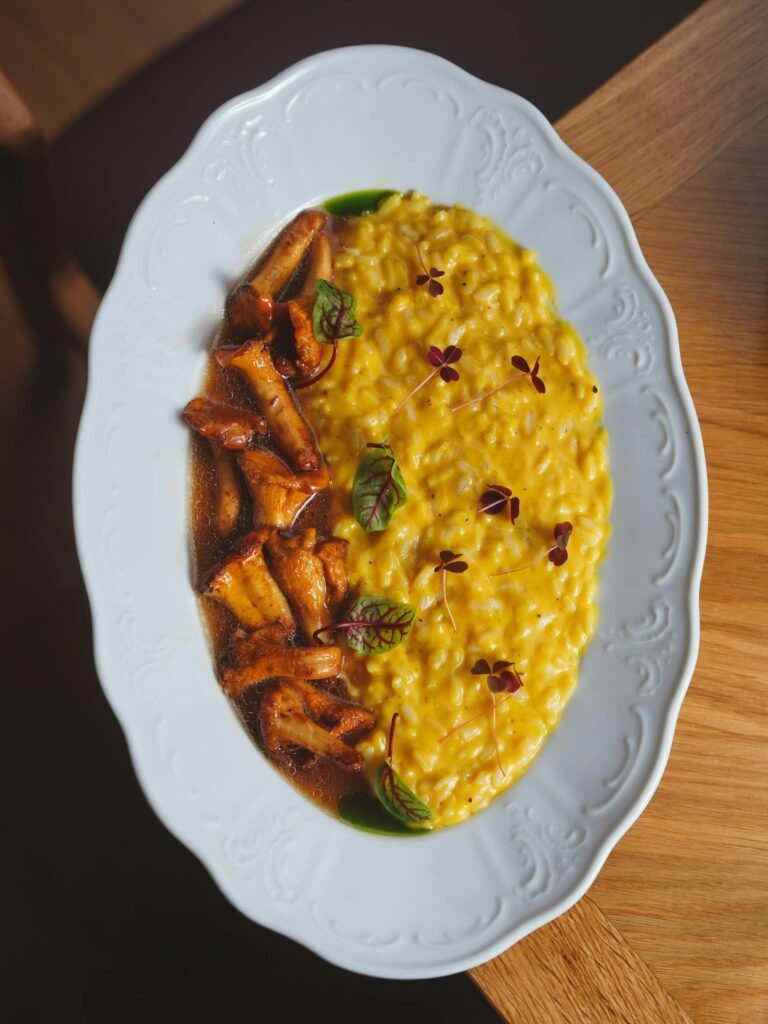 Delicious saffron risotto with mushrooms served on fine white porcelain — Milan's signature dish