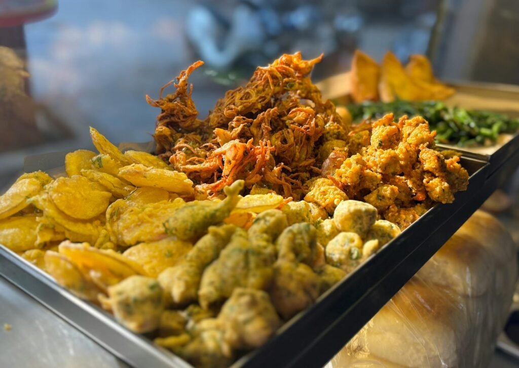 A vibrant display of assorted Mumbai street food snacks featuring pakora, bhajia, and traditional Indian fritters