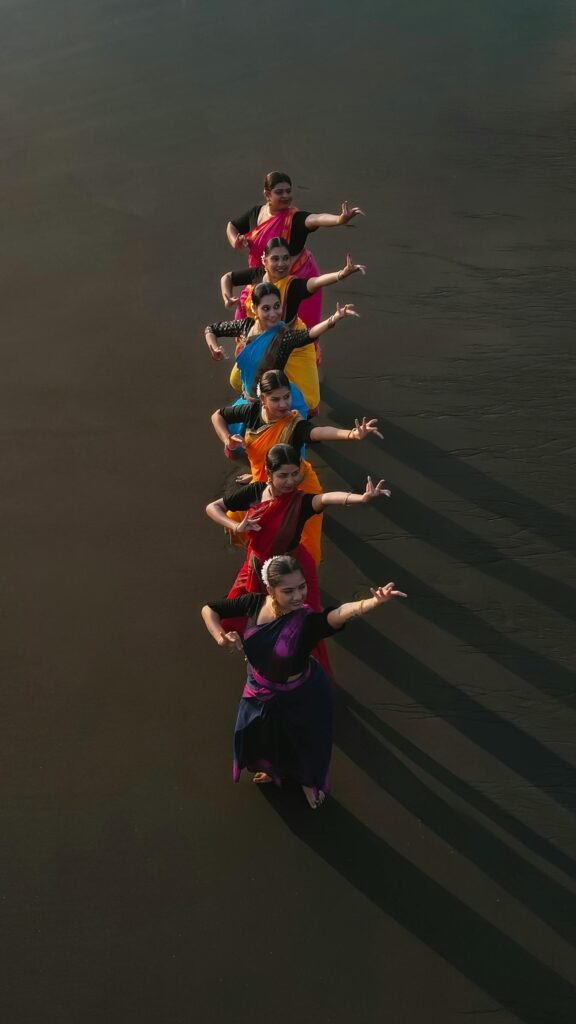 A group of dancers performing traditional Indian dance in colorful sarees on a Mumbai beach