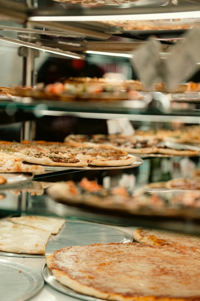 Mouth-watering display of New York-style pizza slices ready to serve — the iconic NYC street meal